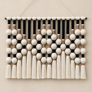 Black studio on cream, bead grid and tassels, yarn-wrapped spheres, wrapped cord