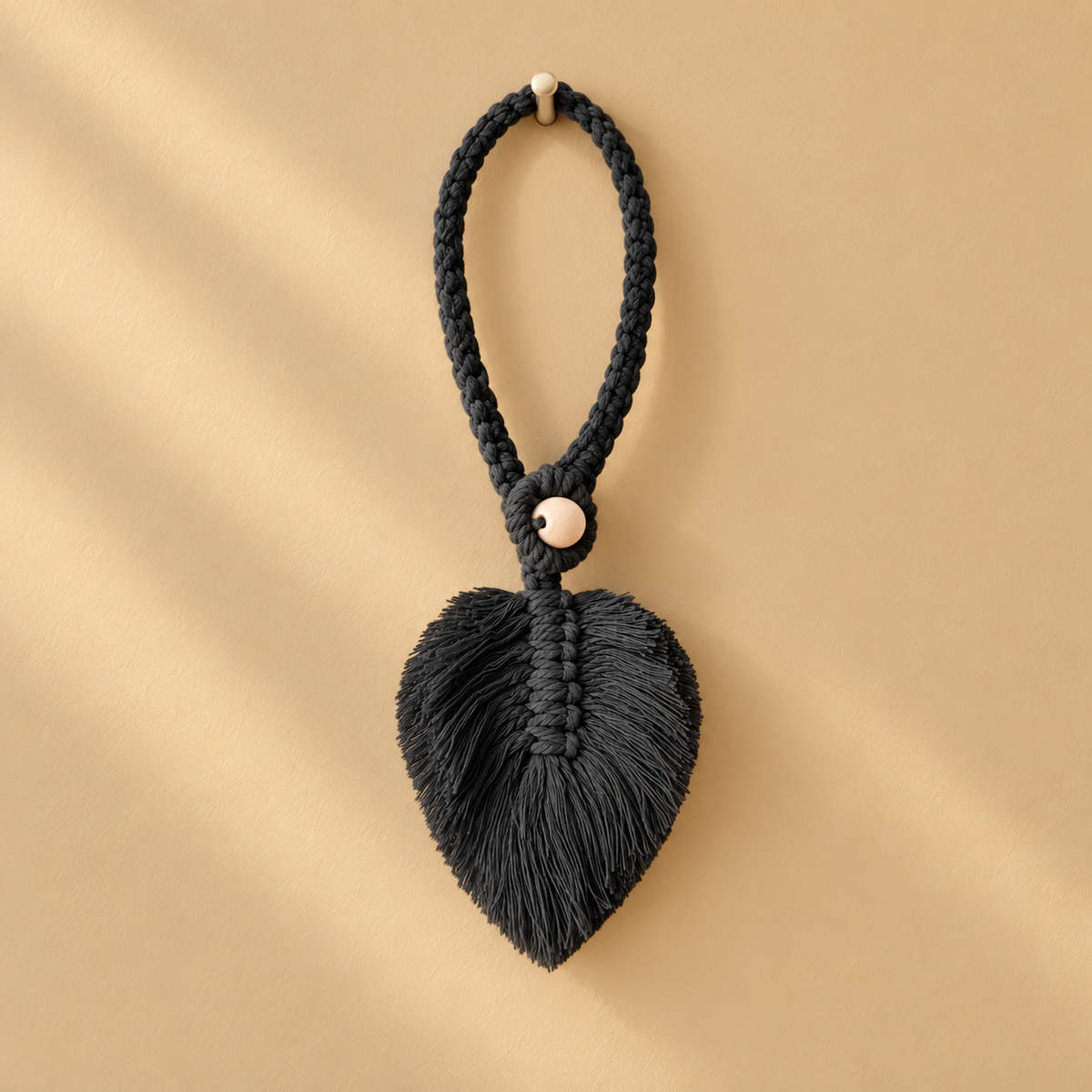 Black studio on ochre, macrame leaf holdbacks in 6 colors, twisted cord, combed flat at the leaf, round pale wooden bead
