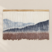 Dip dyed wall hanging with a pale blue sky, navy peaks and dusty rose foreground