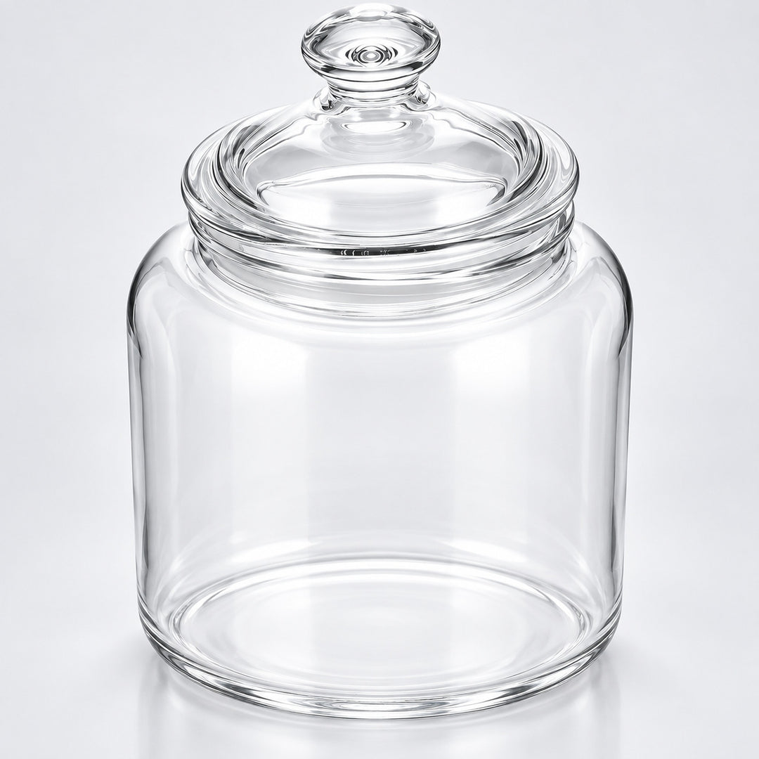 Clear glass jar with a matching glass lid and knob, photographed on a clean light gray to white studio background.