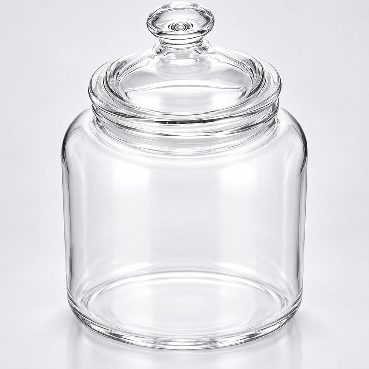 Clear glass jar with a matching glass lid and knob, photographed on a clean light gray to white studio background.