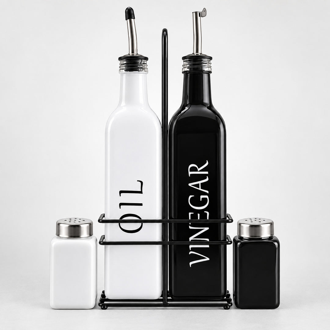 A set of kitchen bottles and shakers on a black metal stand against a light gray background. The set includes a tall white bottle labeled 'OIL', a tall black bottle labeled 'VINEGAR', a small white shaker, and a small black shaker with silver metal tops.