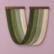Green studio on pink, two battens crossing into one deep v, fine twisted cord, two dark stained wood battens