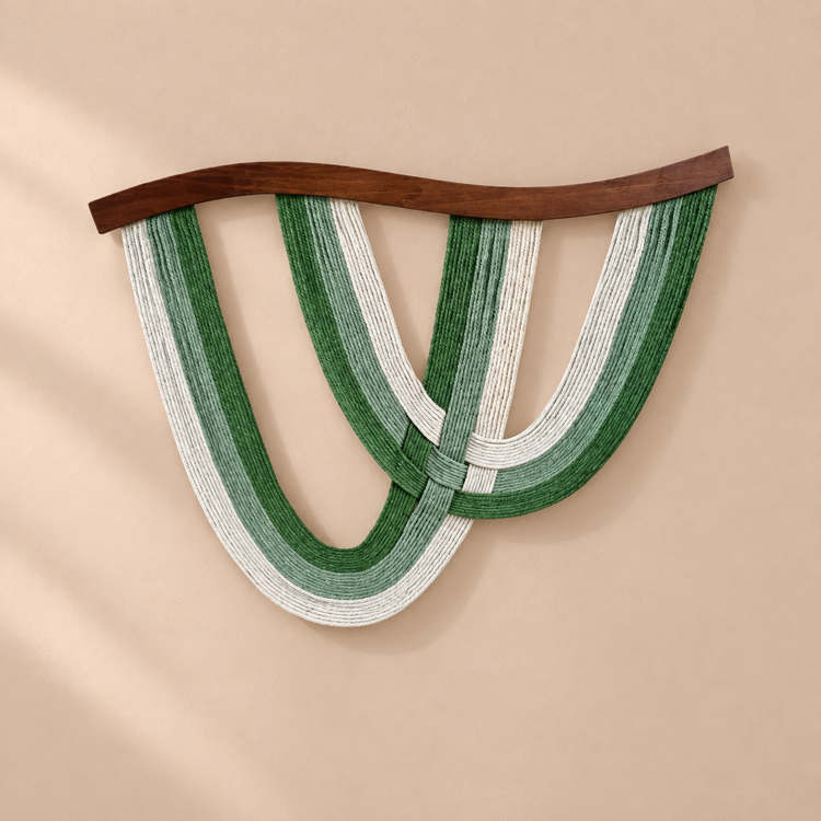 Deep green and cream rope arcs under a curved dark batten on a sand wall