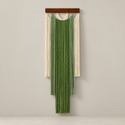 Green and cream stepped fringe wall hanging on a dark batten, pale background