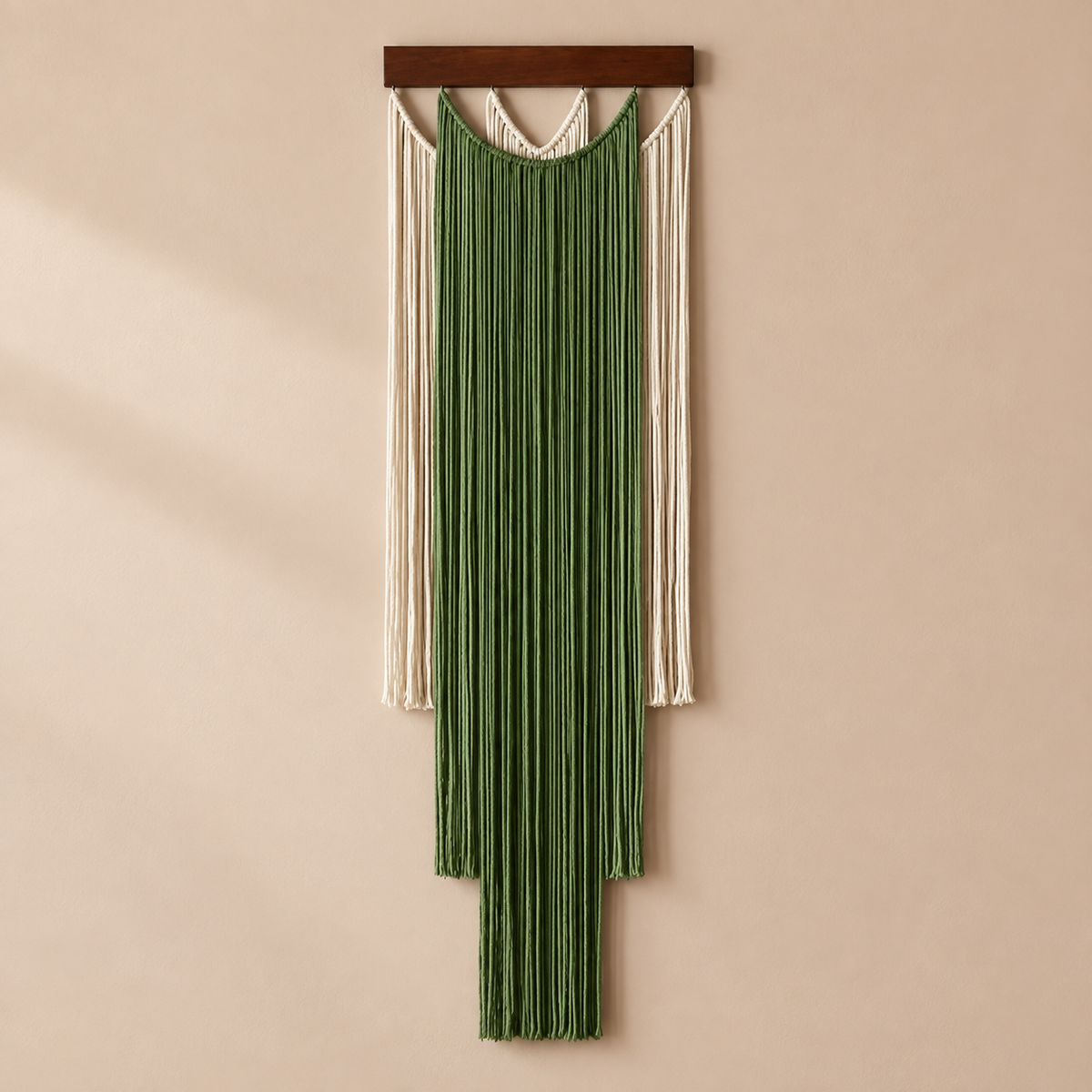 Deep green and cream layered fringe wall hanging with knotted scallops on warm