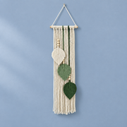 Milky white studio on a blue ground, macrame leaf trio, twisted cord, combed flat at the leaves, pale wooden dowel