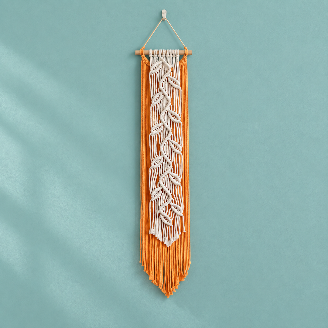 Orange macrame banner with a cream knotted leaf vine down its center on teal