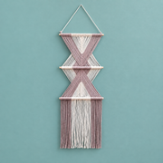 Pink studio on teal, stacked hourglass tiers, twisted cord, short pale dowels