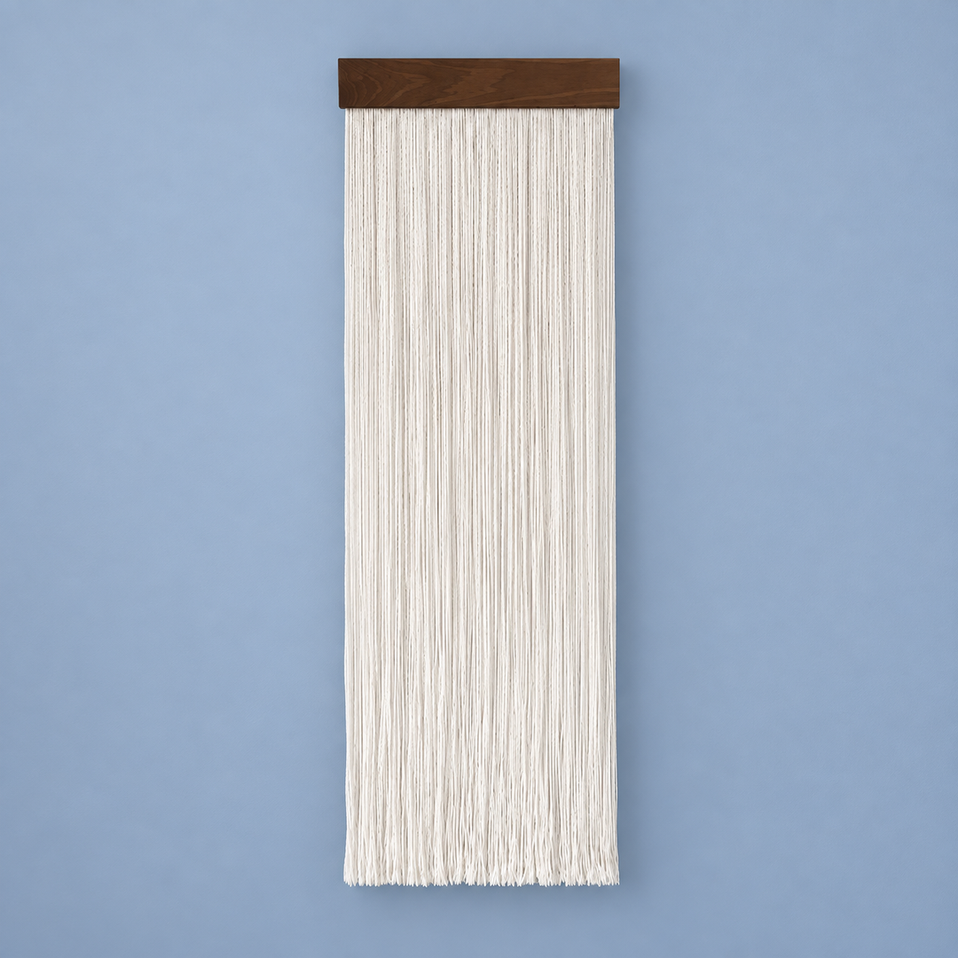 Cream straight cord fringe wall hanging on a dark wood batten against a blue wall