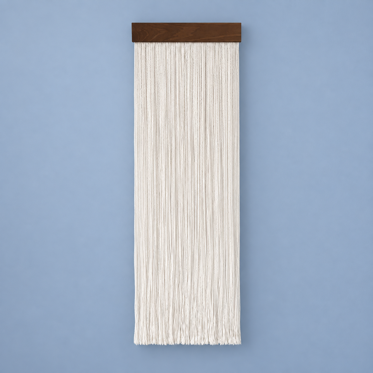 Cream straight cord fringe wall hanging on a dark wood batten against a blue wall