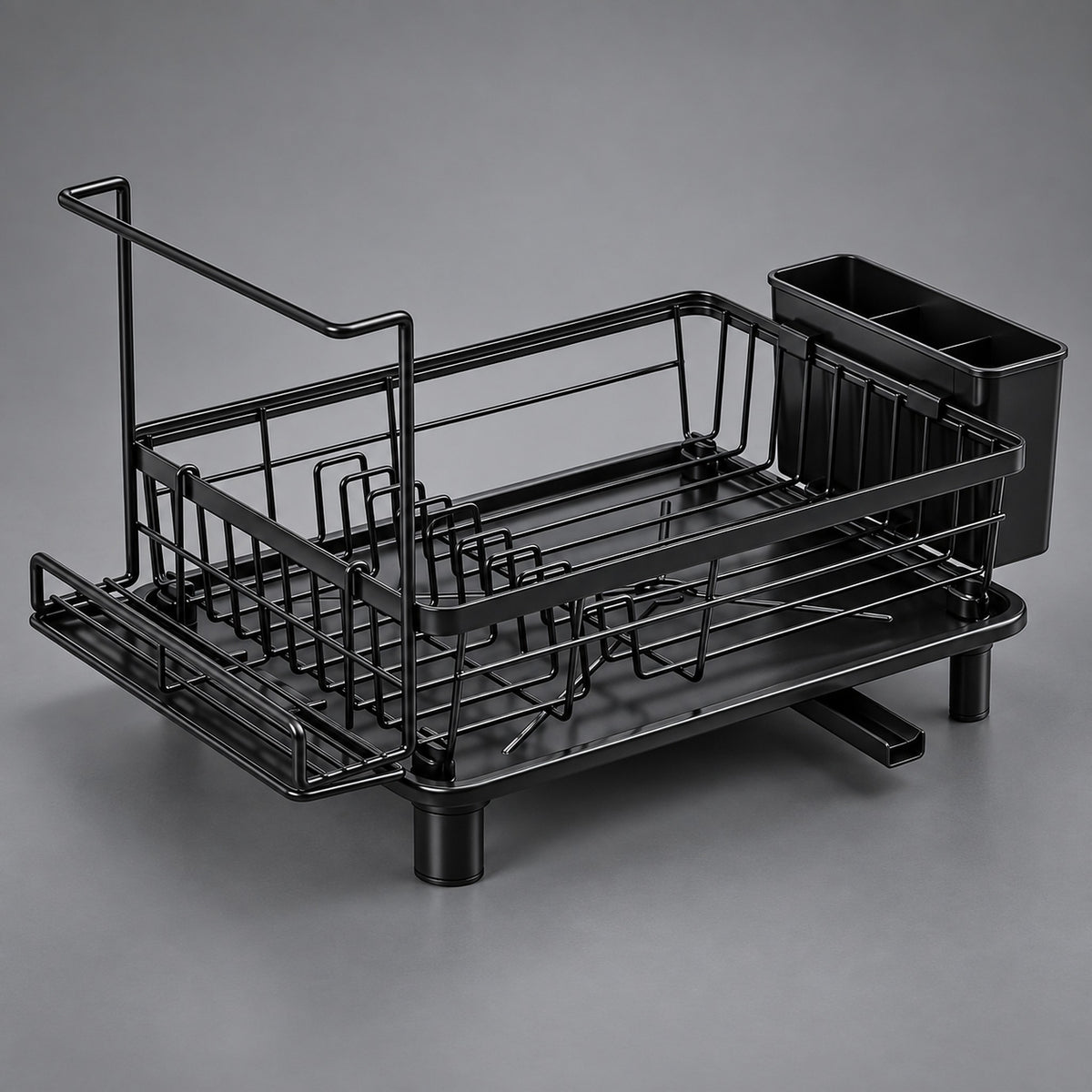 A black metal dish rack with a draining tray, a vertical drying handle, and a side cup holder, photographed on a neutral gray studio background.