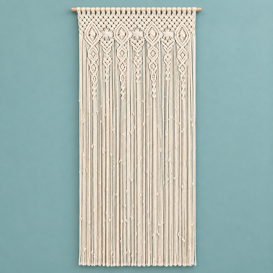 Cream macrame wall hanging with intricate woven patterns and long fringe, suspended from a wooden rod against a solid teal wall.