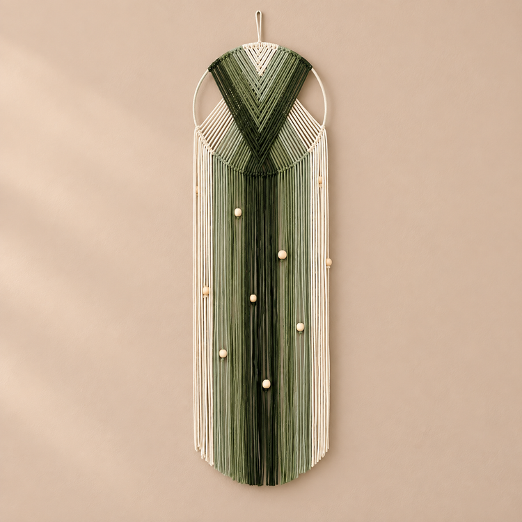 Olive and deep green chevron hoop wall hanging with beads on a warm wall