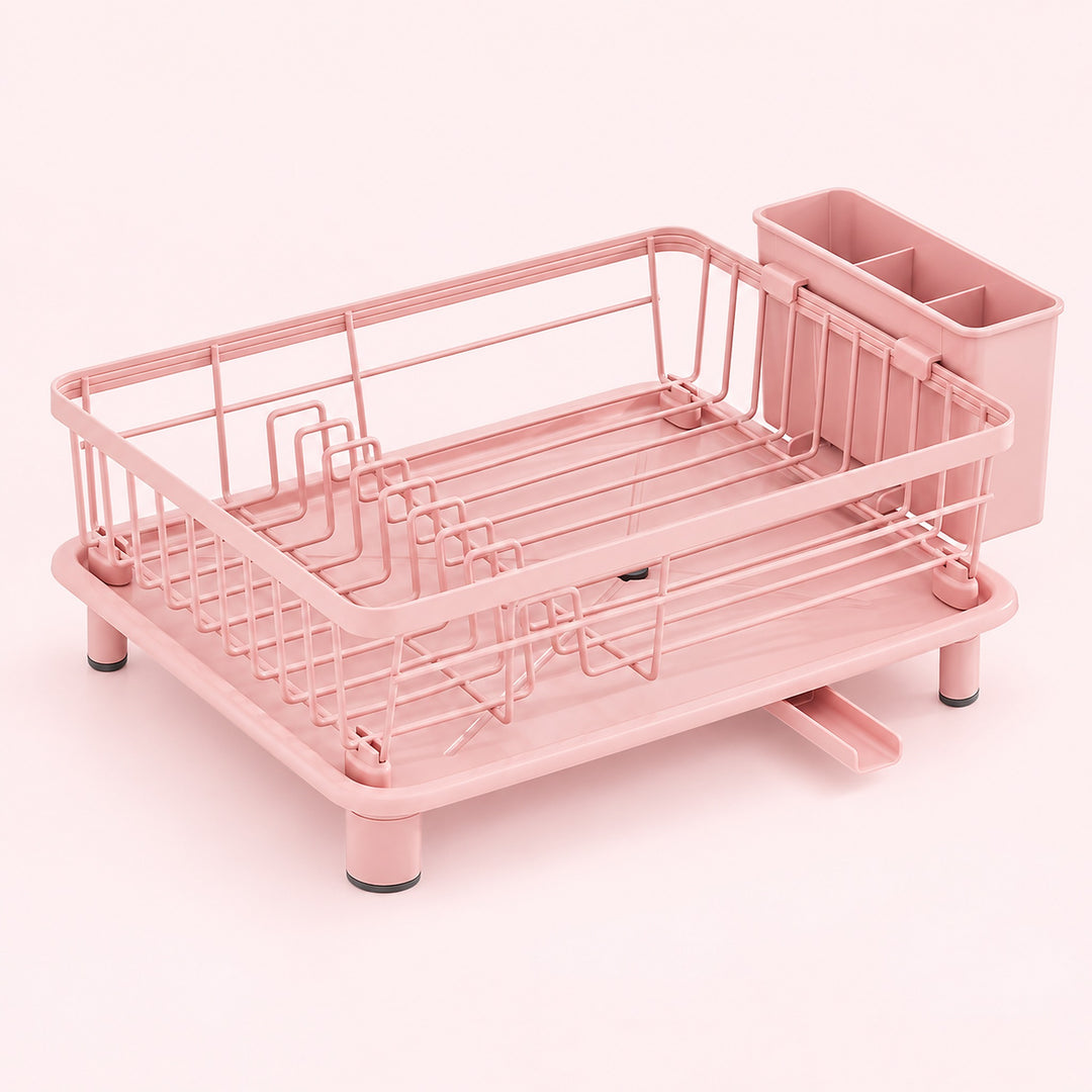A pink metal and plastic dish rack with a matching cup holder, shown on a solid pale pink background.