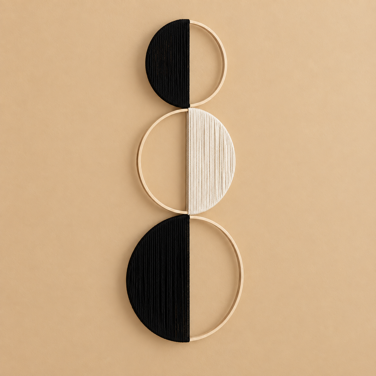 A minimalist wall art piece featuring three vertical stacked geometric shapes made of light wood rings and half-moons, with alternating black and off-white textured panels, displayed on a solid beige background.