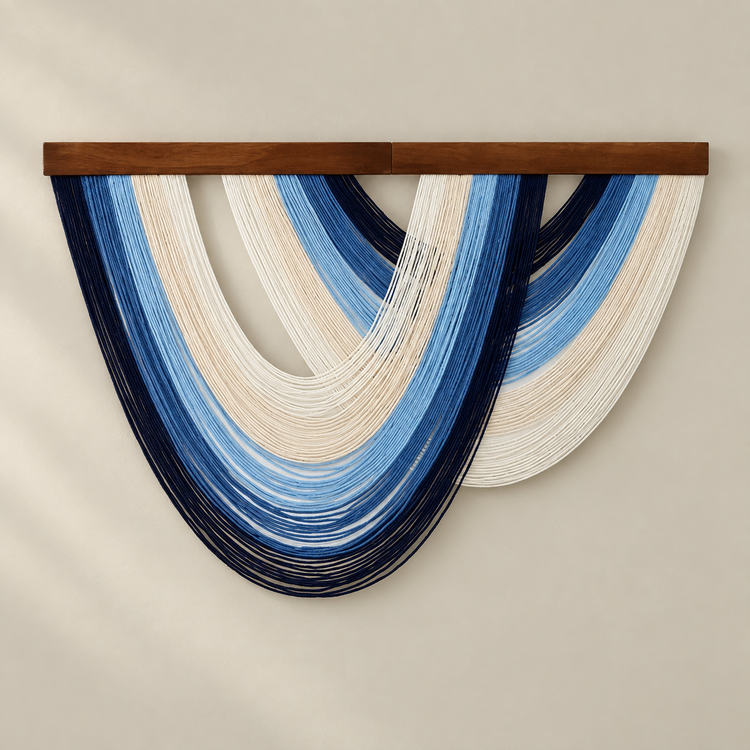 Navy and mid blue open fan fringe wall hanging on a cream background