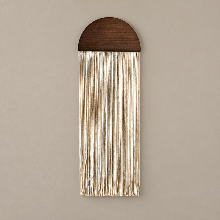 A vertical macrame wall hanging with a dark brown wooden semicircle top and cream-colored woven cords, shown against a solid beige background.