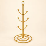 One empty gold six-hook mug tree with circular base.