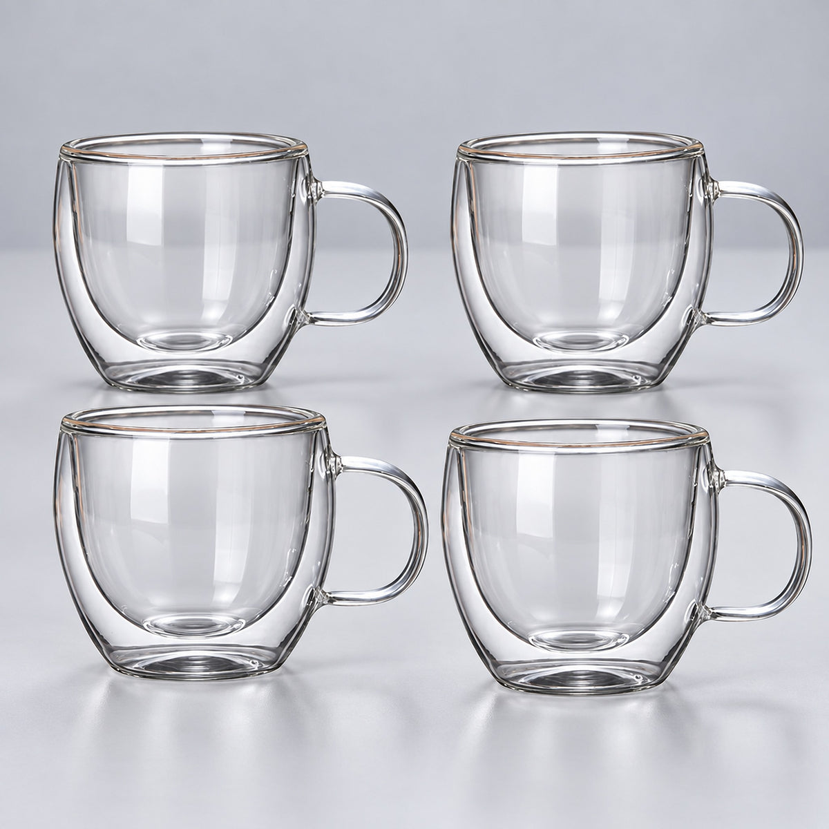 Four empty small 150 ml clear double-wall glass mugs with handles.