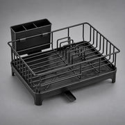 A black plastic and metal dish rack with a built-in organizer cup, shown on a neutral gray background.
