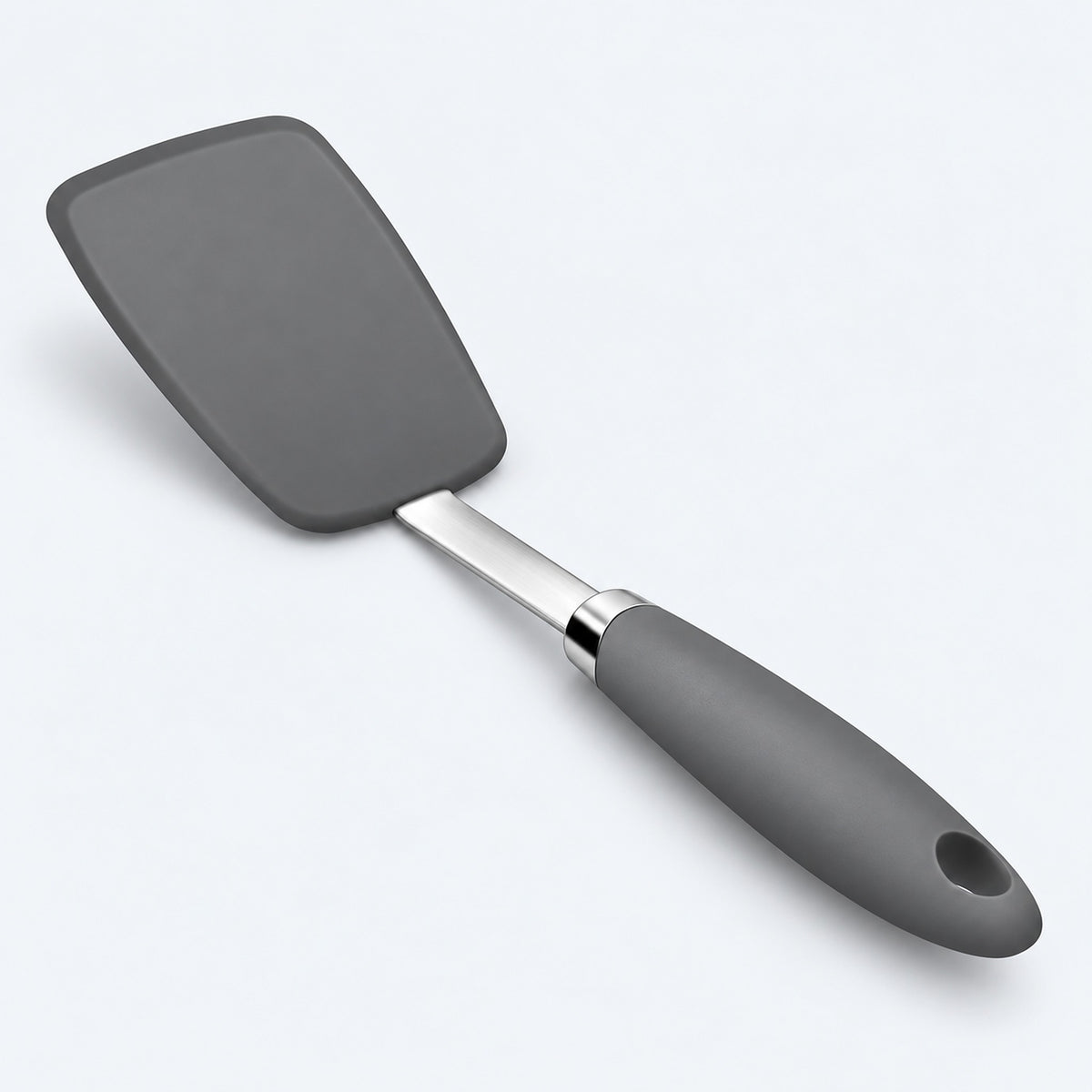 One dark-gray silicone turner spatula on a pale gray studio background.