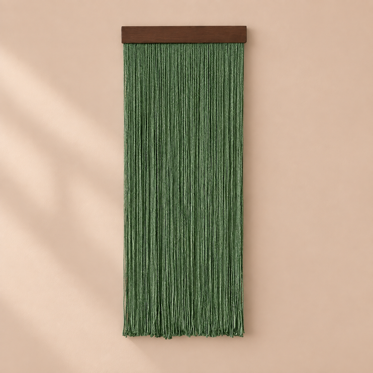 Single deep green fringe panel on a dark batten against a warm wall