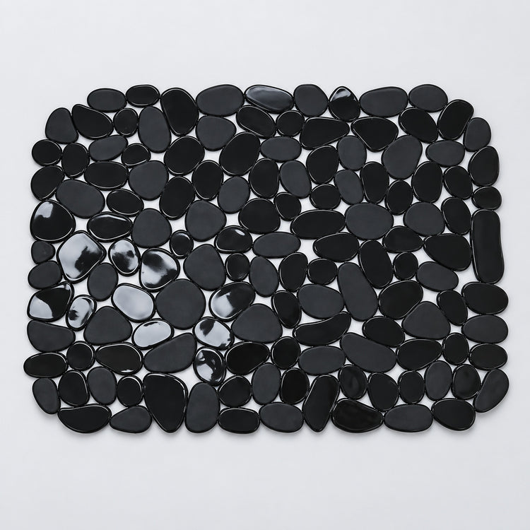 A rectangular mat made of glossy black pebble-shaped stones, photographed from above on a plain light background.