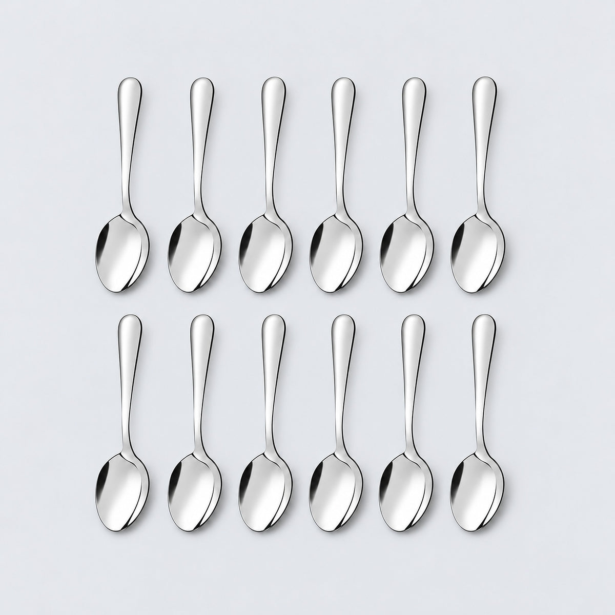 Twelve silver teaspoons arranged in two rows of six on a pale gray background.