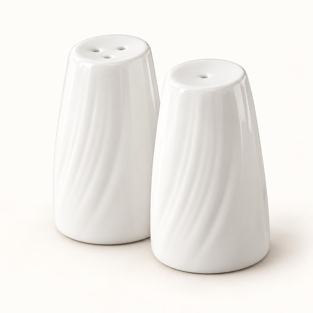 A pair of white ceramic salt and pepper shakers with a textured, wavy vertical rib design, shown on a clean off-white background.