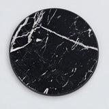 One black artificial-leather coaster, 10 cm.