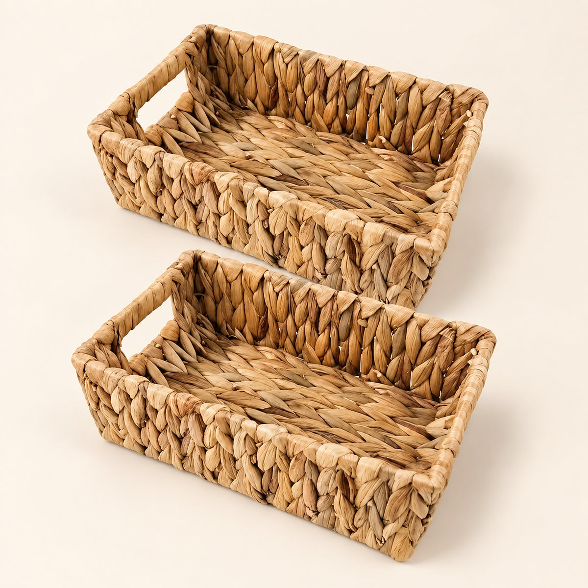 Two rectangular woven storage baskets made from natural seagrass or straw, shown on a clean off-white background.