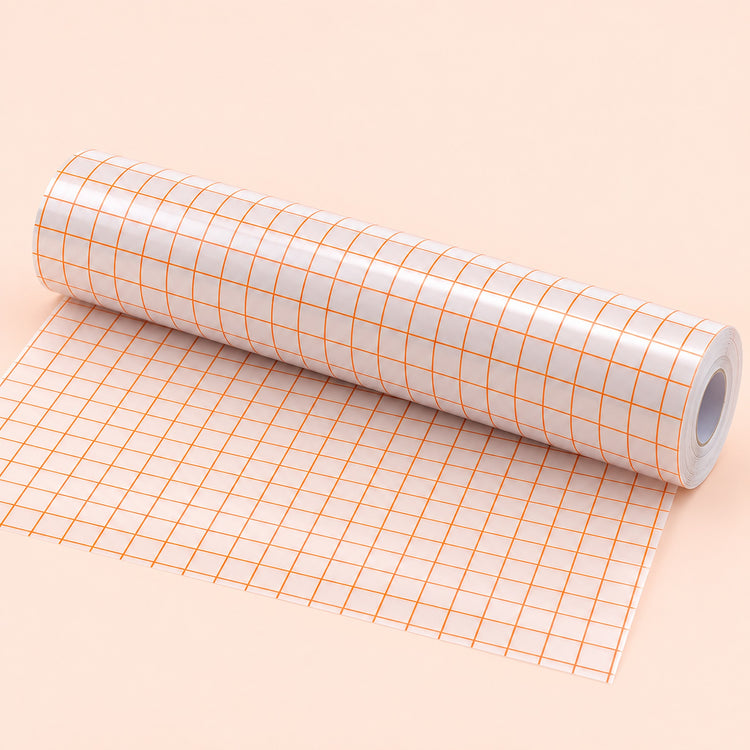 A roll of white adhesive tape with an orange grid pattern, partially unrolled on a solid pale peach background.