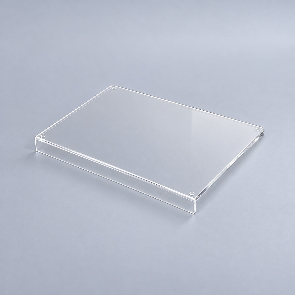 Clear variant: one transparent acrylic cutting board with a counter-edge lip, studio view.
