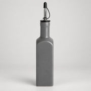 A matte gray rectangular bottle with a pour spout, shown on a light gray studio background.