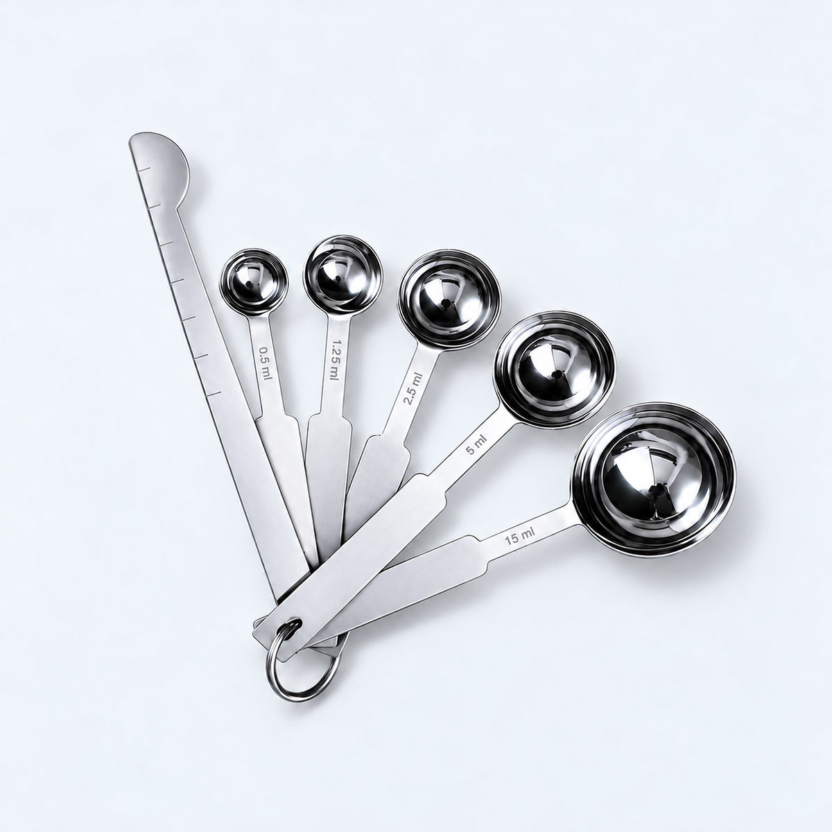 Silver five-spoon set with flat leveler on a pale gray studio background.
