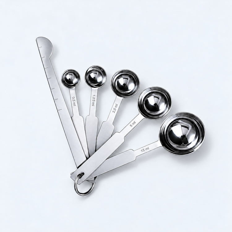 Silver five-spoon set with flat leveler on a pale gray studio background.