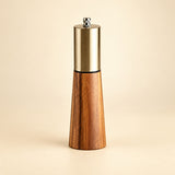 Pepper grinder variant: one acacia wood and gold-colored grinder with a silver top adjustment nut.