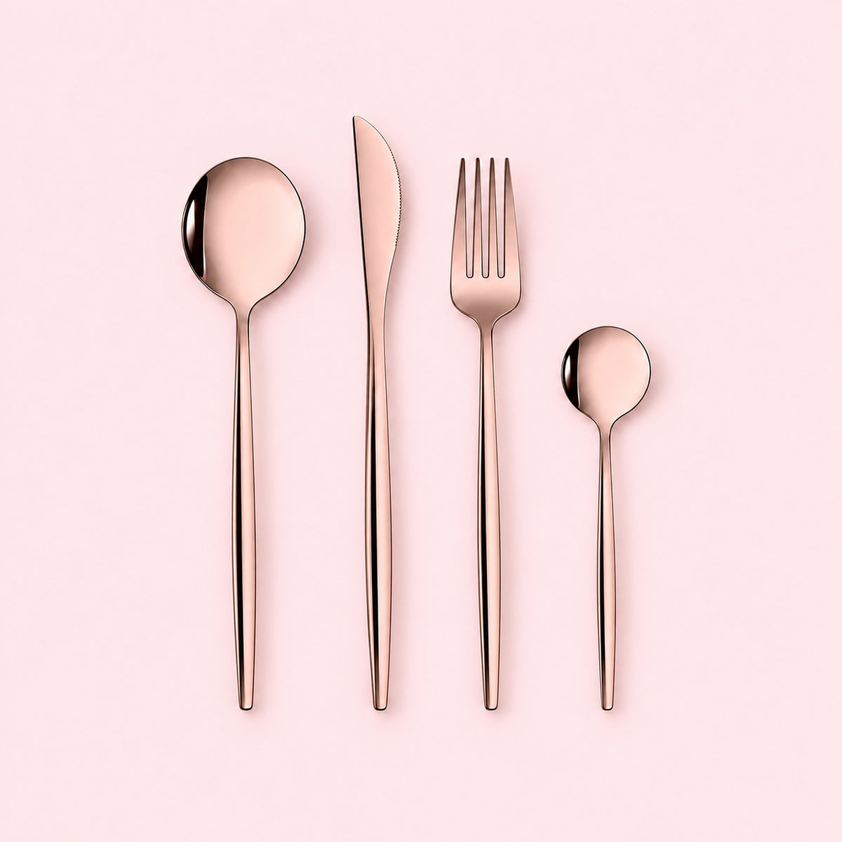 Pink rose-gold four-piece flatware set on a pale pink studio background.