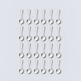 Twenty-four silver teaspoons arranged in four rows of six on a pale gray background.