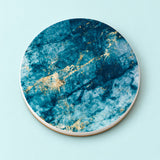 One teal and gold marble printed ceramic coaster on a light studio background.