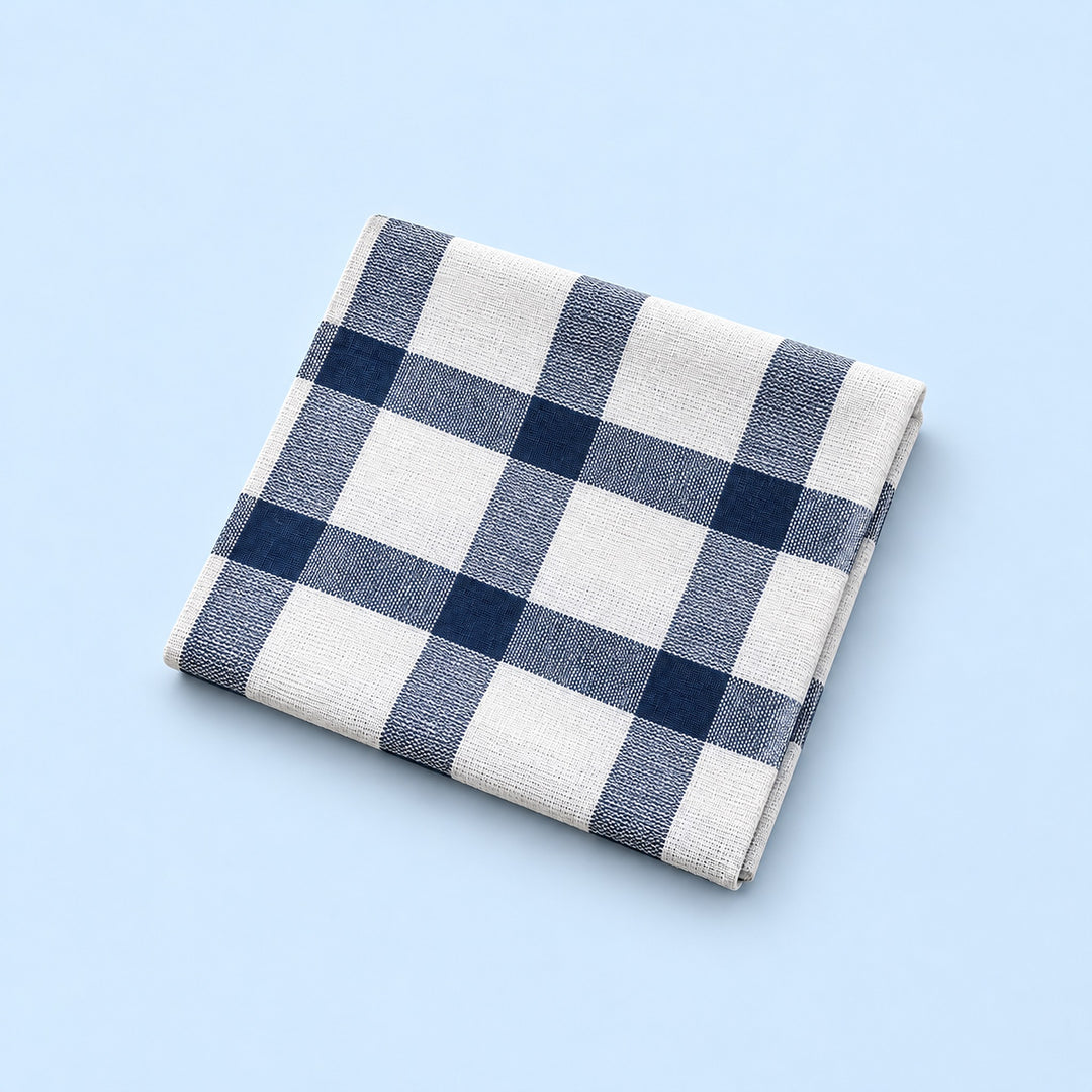 Single white with blue grid cotton towel, folded studio view.