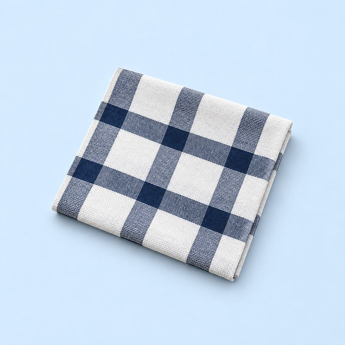 Single white with blue grid cotton towel, folded studio view.