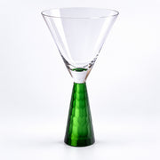 A clear glass martini-style glass with a faceted green stem, photographed on a clean white background.