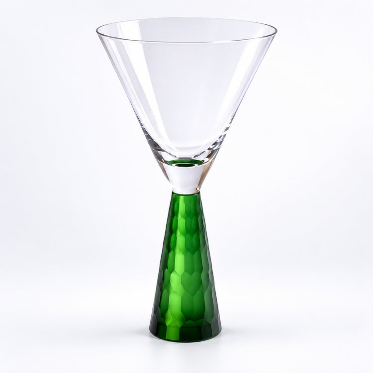 A clear glass martini-style glass with a faceted green stem, photographed on a clean white background.