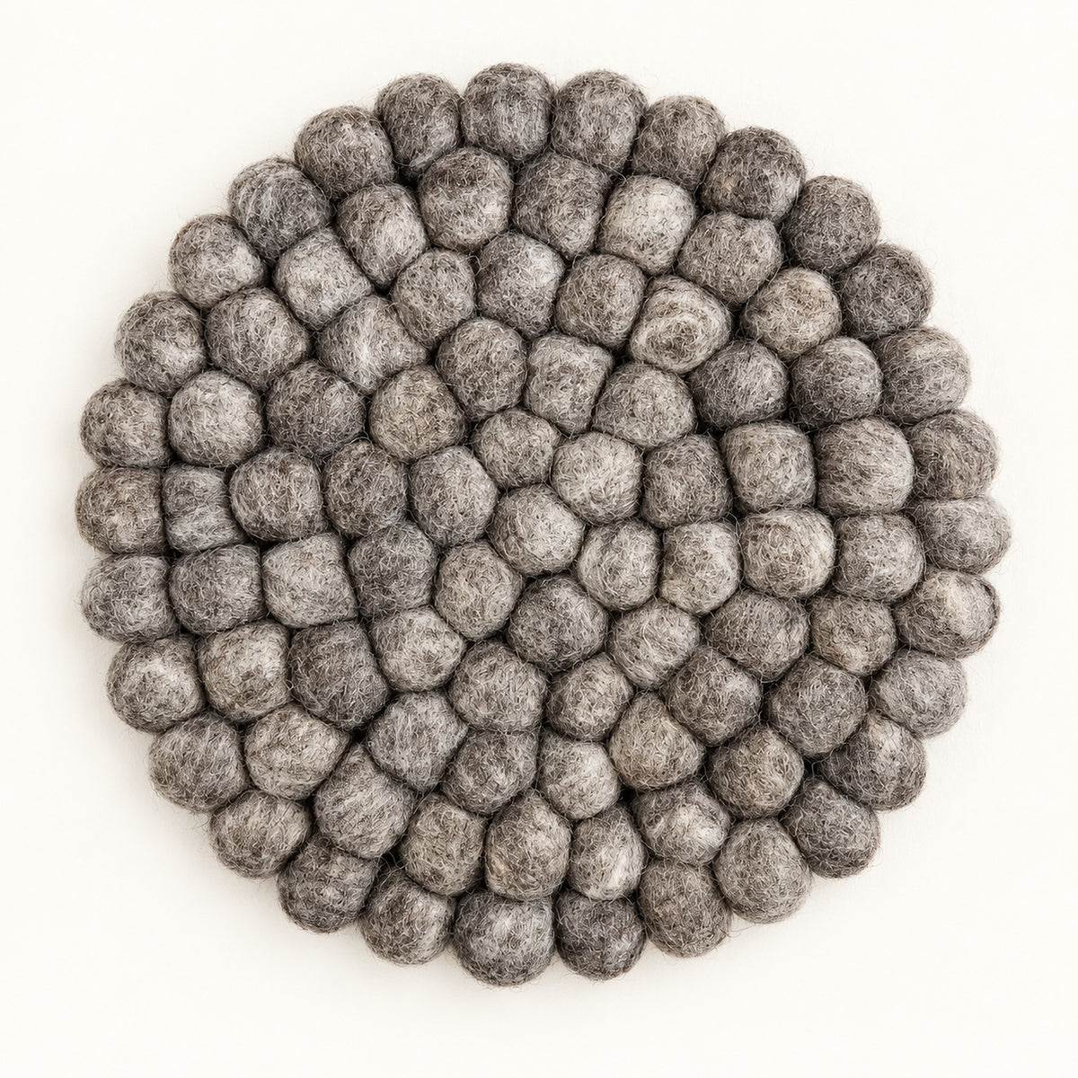 A round gray felt placemat made of textured, raised pom-pom balls, photographed from directly above on a clean white background.