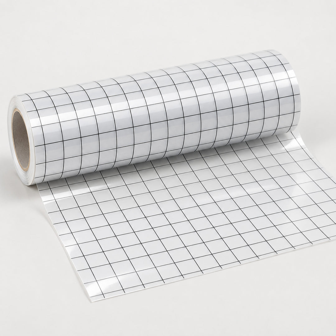 A roll of white adhesive or transfer tape printed with a black grid pattern, partially unrolled on a light gray background.