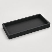 A minimalist black rectangular tray with a low raised rim, shown from an elevated perspective on a light gray background.