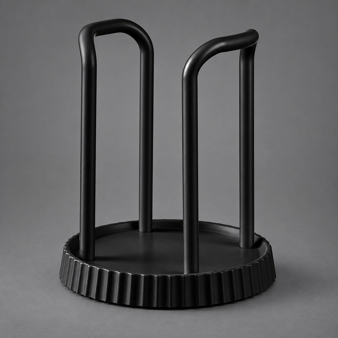A matte black metal wine bottle rack with a circular base and two upright curved arms, shown on a neutral gray background.