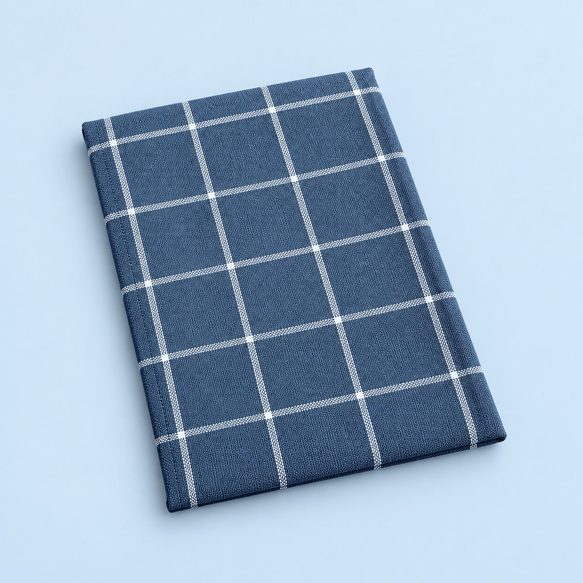 Single blue grid cotton towel, folded studio view.